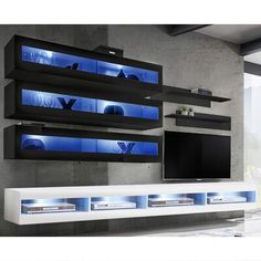 a large television is mounted on the wall in front of a white cabinet with blue lights