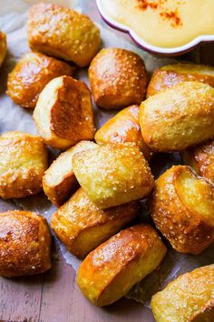 there are many pastries on the table next to some dipping sauces and bread