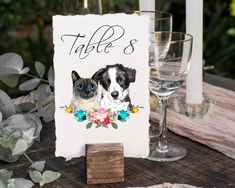 two cats and a dog are sitting on a table with place cards in front of them