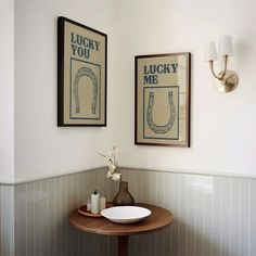 two framed pictures hang above a sink in a bathroom