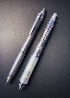 two pens sitting next to each other on a table