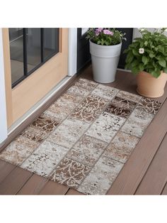 a brown and white door mat sitting on top of a wooden floor next to a potted plant