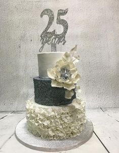 a three tiered cake decorated with flowers and a number 25 on the top layer