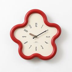 a red and white clock with numbers on it's face against a white background