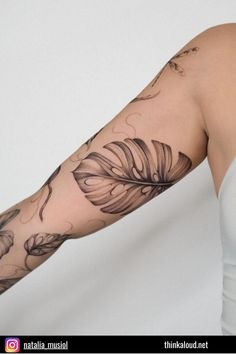 a woman's arm with flowers and leaves tattooed on the arm, in front of a white background