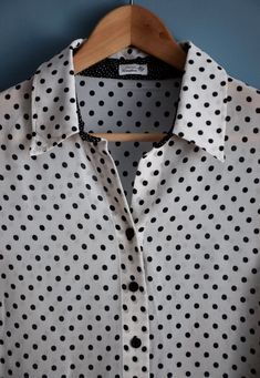 Vintage women's black and white polka dot print blouse, from the 1990s Short sleeve, buttoned blouse with a collar and a black polka dot print on a white background, which on the bottom is contrasted by a white polka dot print on a black background in two differed sizes of the dots. The sleeves have side slits 100% viscose, slightly transparent fabric Size - marked 22 DE , this is the German sizing for shorter women (< 164 cm), corresponds to 44 DE or XL. If you are taller than that, please l Polka Dot Shirt With Button Closure For Work, Classic Fitted Polka Dot Blouse, Polka Dot Button-up Blouse For Work, Polka Dot Collared Blouse With Button Closure, Classic Fitted Polka Dot Tops, Fitted Polka Dot Shirt For Work, Black Summer Blouse With Collared Neckline, Black Collared Blouse For Summer, Summer Polka Dot Collared Blouse