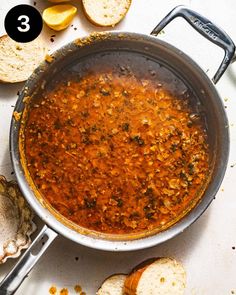 a pan filled with food next to bread