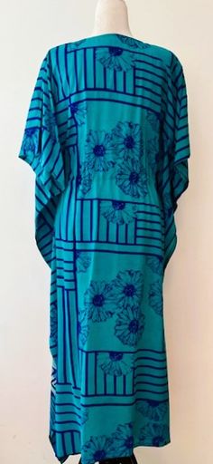 Beautiful Silk Caftan. Beach or Pool Perfect. Classic drawstring body with wide side flutter panels, V-neck. Exceptional blend of blues tansitioning to aqua. Rich contrast of colors. Stripe graduates down to defined bands of color. Covered tunnel empire tie adjusts to your body dimensions. Flattering cut. Classic silhouette that remains one of the top styles for resort and beach wear. Gorgeous as a swim cover up or wear with a slip for a perfect poolside lounger. Perfect for lounging and also gift giving. Highlights: Handmade, shades of blue, Handmade, Draw String at the center for fitting and styling. Materials: 100% SilkCare: Handwash in cold water with mild soap. Line dry or drip dry. One Size fits most. Overall length 52 inches. Bust/chest size - Free Size ( Drawstring ) V Shape Neck W Blue Kaftan With Kimono Sleeves For Beach Season, Blue Casual Kaftan For Poolside, Blue Kaftan With Kimono Sleeves For Summer, Casual Blue Kaftan For Poolside, Vibrant V-neck Kaftan For Beach Cover-up, Tropical Blue Kaftan For Beach Cover-up, V-neck Kaftan With Vibrant Print For Beach, Beach V-neck Batik Print Kaftan, Poolside Loungers