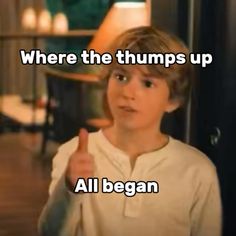 a young boy giving the thumbs up sign in front of him with words written on it