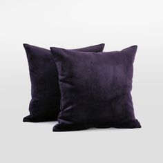 two purple velvet pillows sitting on top of each other