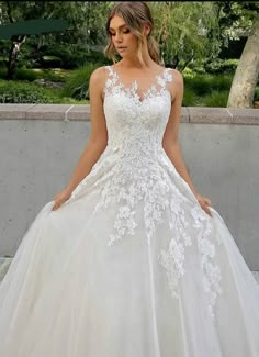 a woman in a white wedding dress standing outside