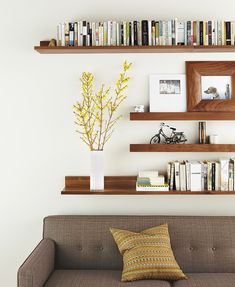 a living room filled with furniture and bookshelves next to a wall full of books