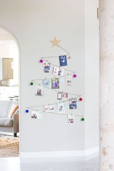 a christmas tree made out of pictures and magnets on a wall in a living room