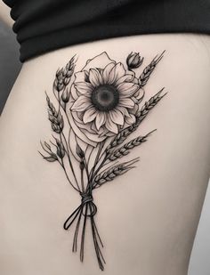 a black and white photo of a woman's stomach with flowers on it,