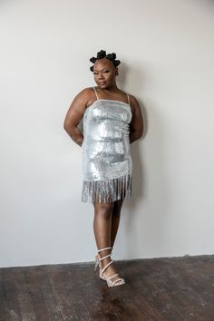 This Silver fringe dress will make you sparkle! Boasting silver sequins and beautiful fringe details, it’s perfect for any night out. Radiate elegance and light up the room in this beautiful dress. model 1 is wearing a large model 2 is wearing a small Mini Flapper Dress With Fringe For Party Season, Summer Sequin Fringe Dress For Night Out, Glamorous Summer Sequin Dress With Fringe, Glamorous Summer Flapper Dress With Rhinestone Fringe, Glamorous Beaded Fringe Dress For Date Night, Rhinestone Fringe Mini Dress For Prom Party Season, Glamorous Fringe Mini Dress For Party, Party Season Mini Dress With Rhinestone Fringe For Prom, Glamorous Mini Length Sequined Flapper Dress