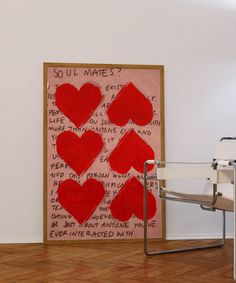 a painting with red hearts on it next to a chair