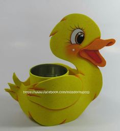 a yellow rubber ducky sitting next to a cup