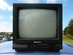 an old television sitting on top of a car