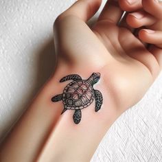 a woman's arm with a turtle tattoo on it