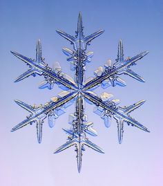 the snowflake is shaped like an airplane flying in the sky with it's wings spread out