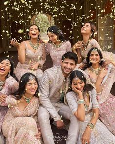 the bride and grooms are posing for a group photo with confetti thrown in the air