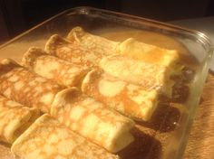 pancakes are sitting in a glass dish on a wooden counter top, ready to be cooked