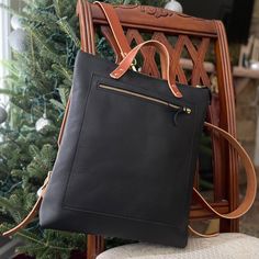 The Kodiac Leather Backpack - Tote in Black This beautiful full-grain Kodiac leather backpack /tote is perfect for everyday uses and for travelers. This soft and stylish backpack features veg-tanned straps and brass hardware and copper rivets. This bag is a convertible tote or backpack with an interior pocket and adjustable straps. This bag will fit laptops, books and more. Handcrafted in our North Carolina workshop of the finest full-grain leather, our bags are durable, as they are beautiful an Rectangular Leather Backpack For Everyday Carry, Rectangular Leather Backpack With Leather Lining For Everyday Carry, Rectangular Backpack With Leather Lining For Everyday Use, Rectangular Leather-backed Backpack For Everyday Carry, Everyday Leather Backpack With Leather Backing, Leather Backpack For Everyday Use, Rectangular Backpack With Leather Backing For Everyday Carry, Everyday Carry Soft Leather Backpack, Soft Leather Everyday Backpack