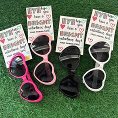 five pairs of sunglasses sitting on top of a green grass covered field next to cards