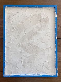 a blue and white painting on a wooden surface