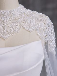 the back of a wedding dress with beading and pearls on it's neck