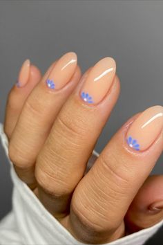 a woman's nails with blue flowers on them