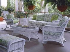 a porch with wicker furniture and potted plants