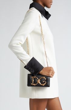 A D&G logo with baroque-inspired gilt flourishes ornately brands this compact leather bag designed with a sliding chain strap that can be worn doubled or long. Magnetic-snap flap closure Pull-through chain strap Interior card slot Leather lining Leather Made in Italy Designer Handbags Elegant Black Shoulder Bag With Gold-tone Logo, Elegant Gold Shoulder Bag With Branded Hardware, High-end Formal Bags With Gold-tone Logo Plaque, Elegant Rectangular Shoulder Bag With Gold-tone Logo, Black Wallet On Chain With Gold-tone Logo For Evening, Chic Formal Wallet On Chain With Gold-tone Logo, Black Wallet On Chain With Gold-tone Logo Plaque, Black Wallet On Chain With Gold-tone Logo, Chic Evening Wallet On Chain With Metal Logo