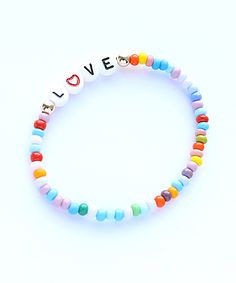 a bracelet with the word love written on it and multicolored beaded beads