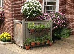 a brick house with flowers and plants in the front yard