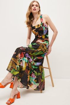 With all the charm of a well put-together bouquet, this vibrant maxi dress shows off bold sprays of tropical blooms printed onto soft, lightweight fabric. Flowing down to the floor, it guarantees a dramatic entrance and features a feminine halter neckline, crossover back straps and subtle textured trims lining the tiers. Tie the bow at the back in a ladylike loop for a final head-turning flourish. Tropical Maxi Dress For Spring, Tropical Style Spring Maxi Dress, Tropical Print Maxi Dress For Garden Party, Tropical Maxi Length Dress With Floral Print, Tropical Floral Print Maxi Dress For Garden Party, Tropical Maxi Dress With Tropical Print For Garden Party, Tropical Floral Maxi Dress For Garden Party, Tropical Multicolor Maxi Dress For Garden Party, Multicolor Maxi Dress With Tropical Print