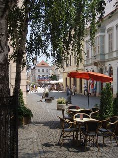 an empty street with tables and chairs on it