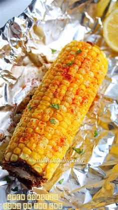 grilled corn on the cob in foil with lemon wedges