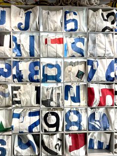 many bags are stacked on top of each other with numbers and letters printed on them