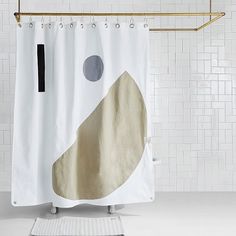 a white shower curtain with black and grey circles on it next to a tiled wall