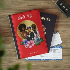 two girls trip books next to a passport and car keys on a wooden table top