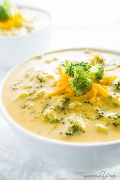 a bowl filled with broccoli and cheese on top of a table