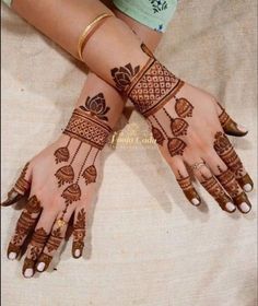 two hands with henna tattoos on them