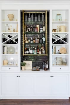 a white bookcase filled with lots of bottles