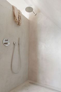 a bathroom with a shower head and hand held shower faucet in the corner