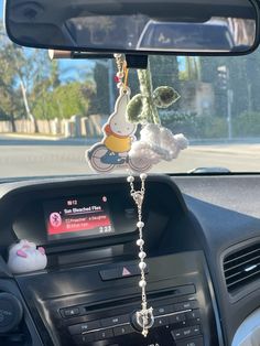 a car dashboard with stuffed animals hanging from the dash board