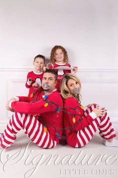 a man and two children in matching christmas pajamas are posing for a photo with santa clause on