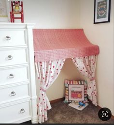 a child's bedroom with a pink canopy bed and white dresser in the corner