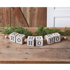 three wooden blocks with the word ho ho written on them sitting on top of a table