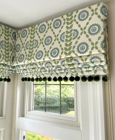 a window with a green and blue patterned valance